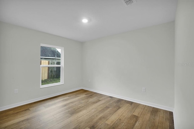 unfurnished room with visible vents, baseboards, and wood finished floors