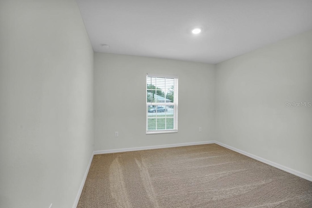 carpeted spare room with baseboards