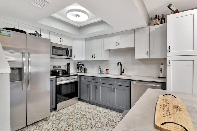 200 Meres Blvd Unit 7, Tarpon Springs, FL 34689 - kitchen with stainless steel appliances, a sink, a raised ceiling, light countertops, and backsplash