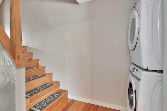 200 Meres Blvd Unit 7, Tarpon Springs, FL 34689 - laundry room featuring stacked washing machine and dryer, wood finished floors, and baseboards