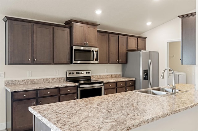 16302 Vine Cliff Ave, Hudson, FL 34667 - kitchen featuring dark brown cabinetry, a sink, appliances with stainless steel finishes, lofted ceiling, and washer and dryer