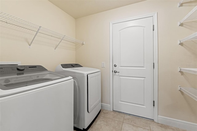16302 Vine Cliff Ave, Hudson, FL 34667 - washroom featuring washing machine and clothes dryer, baseboards, laundry area, and light tile patterned floors