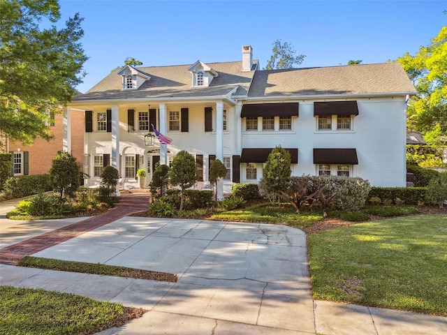 3313 W Mullen Ave, Tampa, FL 33609 - greek revival house featuring a front yard and a chimney