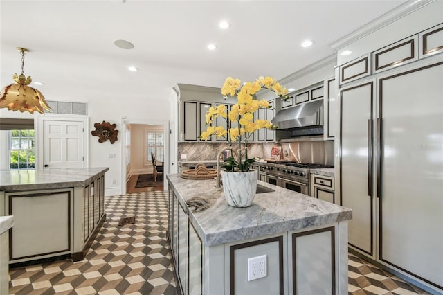 3313 W Mullen Ave, Tampa, FL 33609 - kitchen with high quality appliances, tasteful backsplash, light floors, exhaust hood, and a kitchen island with sink