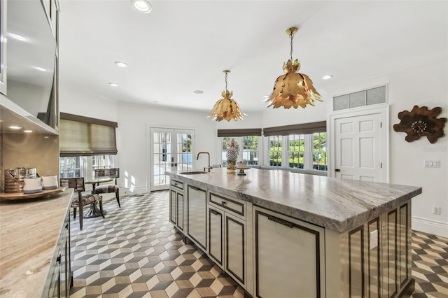 3313 W Mullen Ave, Tampa, FL 33609 - kitchen with a kitchen island with sink, a sink, french doors, and recessed lighting