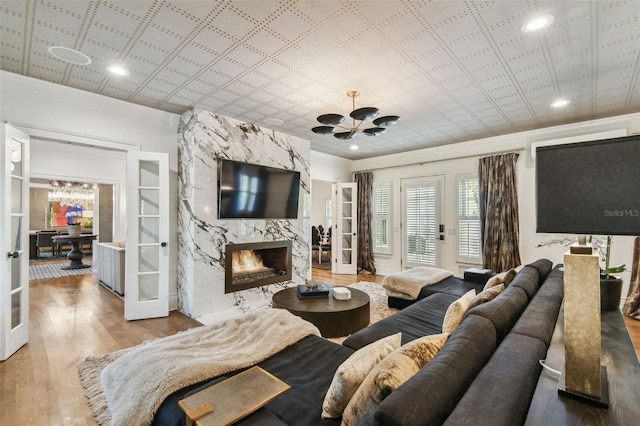 3313 W Mullen Ave, Tampa, FL 33609 - living area featuring french doors, ornamental molding, a chandelier, a high end fireplace, and wood finished floors