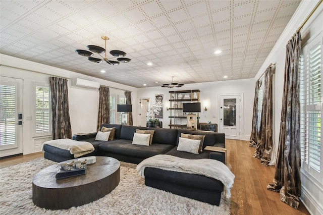 3313 W Mullen Ave, Tampa, FL 33609 - living room with a notable chandelier, a wall mounted AC, wood finished floors, and ornamental molding