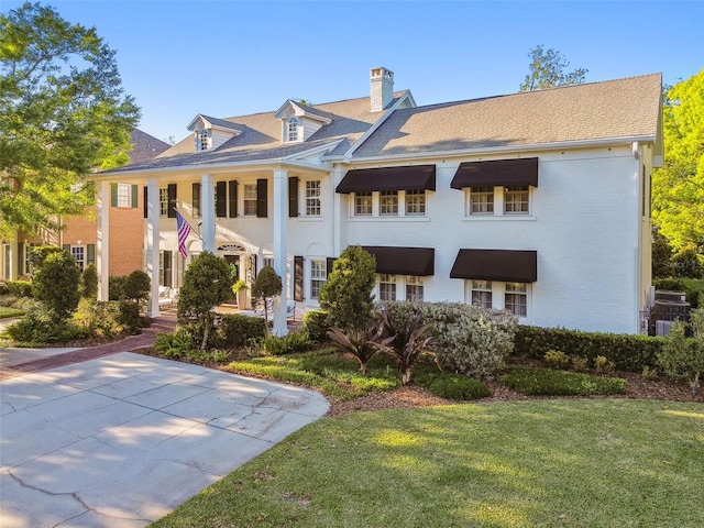 3313 W Mullen Ave, Tampa, FL 33609 - back of property featuring a chimney, brick siding, and a yard