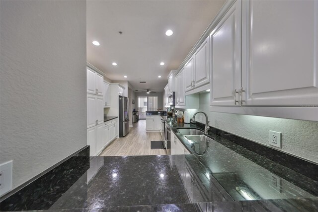 1038 Bellasol Way Unit 202, Apollo Beach, FL 33572 - kitchen featuring a textured wall, stainless steel appliances, white cabinetry, dark stone counters, and recessed lighting