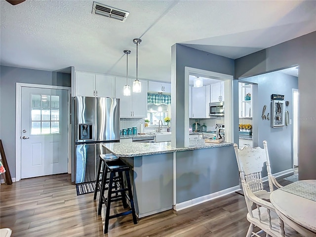 9616 Oak Ridge Ave, Riverview, FL 33578 - kitchen with a sink, white cabinets, visible vents, and appliances with stainless steel finishes