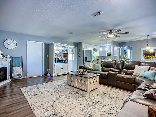 9616 Oak Ridge Ave, Riverview, FL 33578 - living area featuring a textured ceiling, visible vents, baseboards, ceiling fan, and dark wood-type flooring