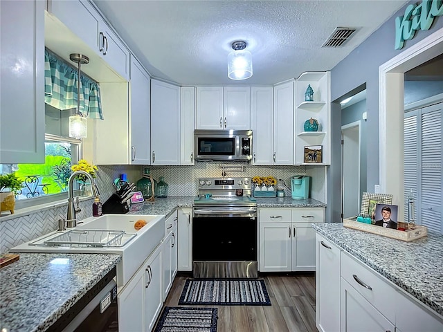 9616 Oak Ridge Ave, Riverview, FL 33578 - kitchen featuring white cabinetry, open shelves, dark wood-style flooring, visible vents, and appliances with stainless steel finishes