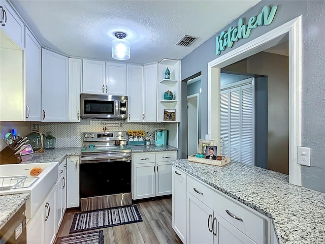 9616 Oak Ridge Ave, Riverview, FL 33578 - kitchen featuring white cabinetry, open shelves, stainless steel appliances, dark wood-style floors, and visible vents