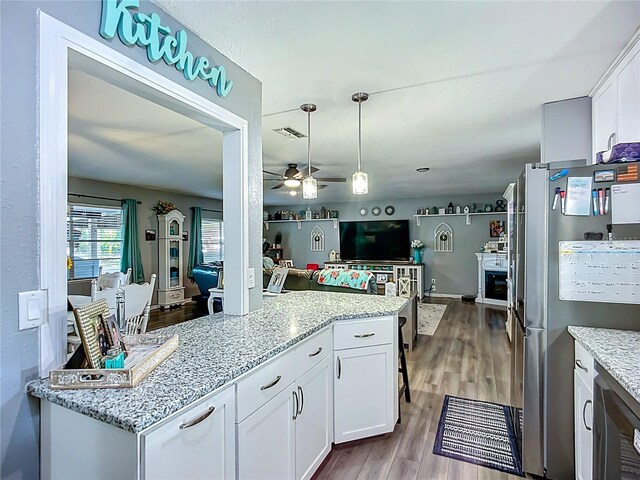 9616 Oak Ridge Ave, Riverview, FL 33578 - kitchen featuring a ceiling fan, freestanding refrigerator, wood finished floors, visible vents, and white cabinets