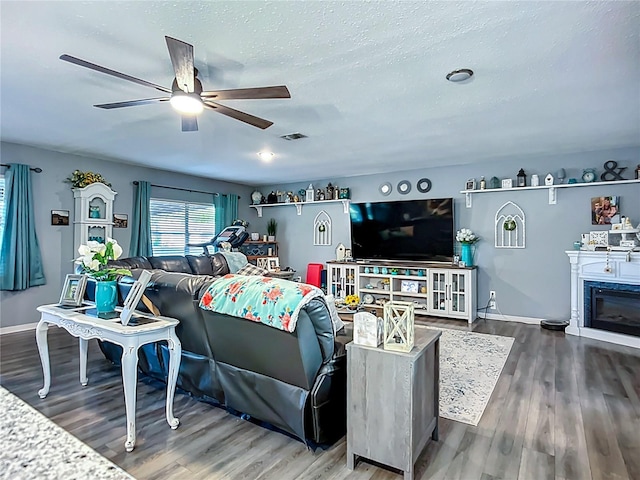 9616 Oak Ridge Ave, Riverview, FL 33578 - living room featuring a textured ceiling, visible vents, baseboards, wood finished floors, and a ceiling fan
