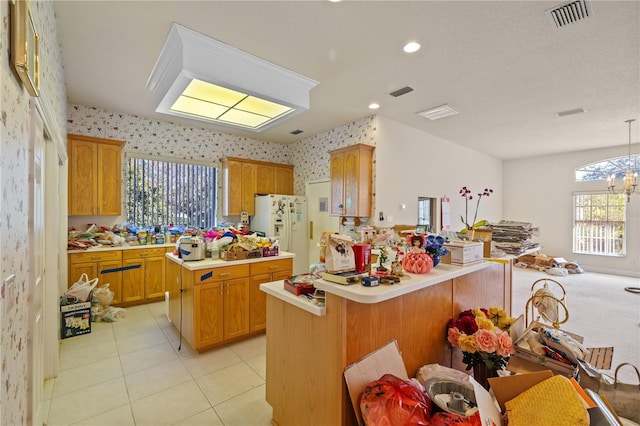 13750 Dowling Ln, Odessa, FL 33556 - kitchen with white fridge with ice dispenser, light countertops, wallpapered walls, a peninsula, and a center island