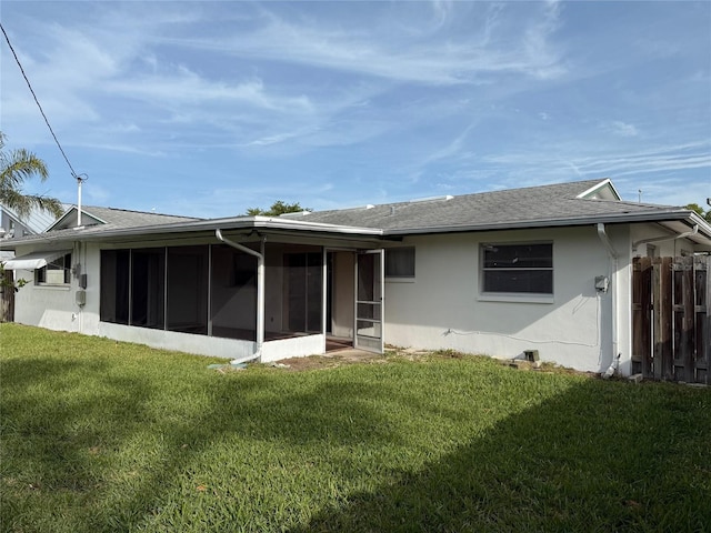 14264 Page Ave, Largo, FL 33774 - back of house with a sunroom, fence, roof with shingles, stucco siding, and a yard