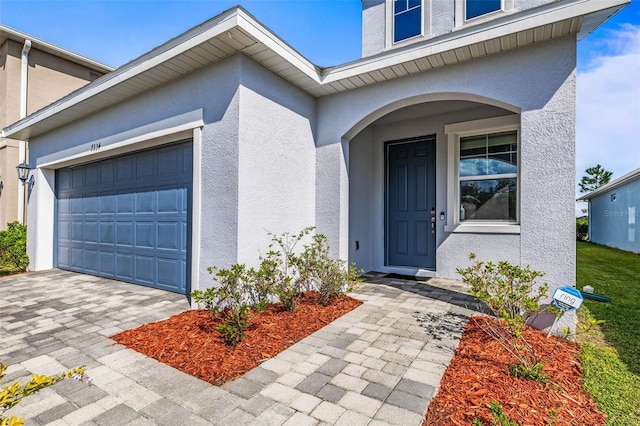 7334 Ashcroft Dr, Wesley Chapel, FL 33545 - view of exterior entry featuring a garage, driveway, and stucco siding
