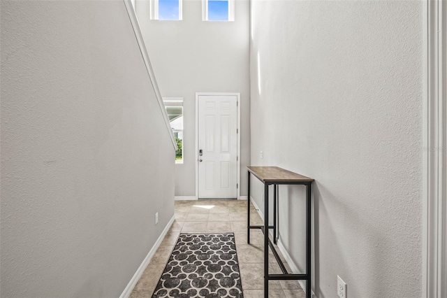 7334 Ashcroft Dr, Wesley Chapel, FL 33545 - hall with light tile patterned flooring, baseboards, and a towering ceiling
