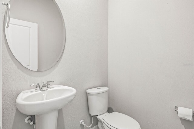 7334 Ashcroft Dr, Wesley Chapel, FL 33545 - bathroom with a textured wall, toilet, and a sink