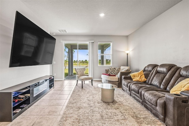 7334 Ashcroft Dr, Wesley Chapel, FL 33545 - living area with a textured ceiling, light tile patterned floors, baseboards, visible vents, and recessed lighting