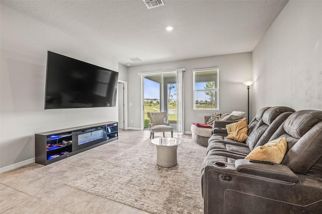 7334 Ashcroft Dr, Wesley Chapel, FL 33545 - living room featuring baseboards, a textured ceiling, and tile patterned floors