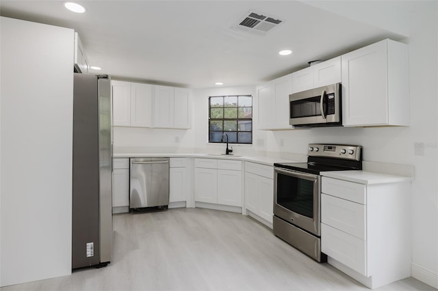 7227 Otter Creek Dr, New Port Richey, FL 34655 - kitchen featuring white cabinetry, light countertops, stainless steel appliances, a sink, and visible vents