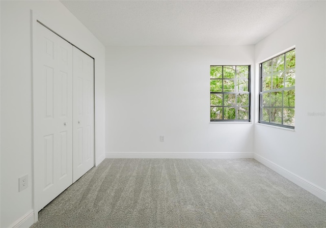 7227 Otter Creek Dr, New Port Richey, FL 34655 - unfurnished bedroom with baseboards, carpet floors, a textured ceiling, and a closet