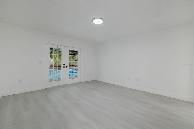 7227 Otter Creek Dr, New Port Richey, FL 34655 - unfurnished room with baseboards, french doors, and light wood-type flooring