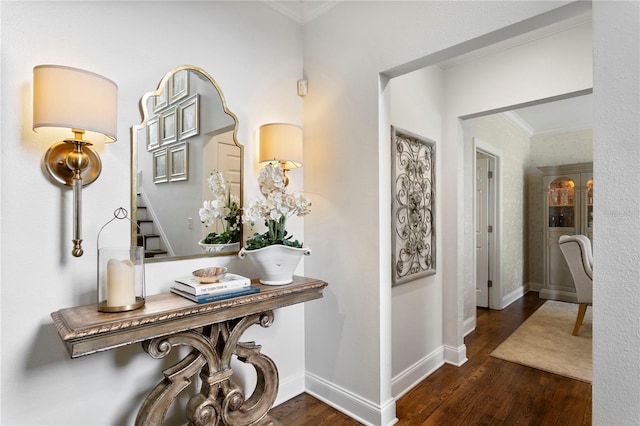 corridor featuring stairway, baseboards, ornamental molding, and wood finished floors