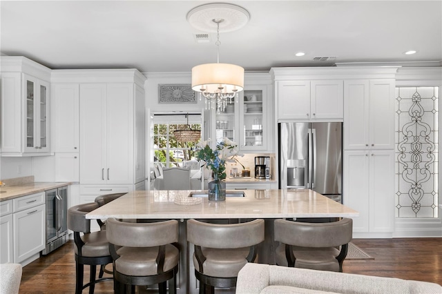 kitchen featuring wine cooler, white cabinets, a kitchen breakfast bar, and stainless steel refrigerator with ice dispenser