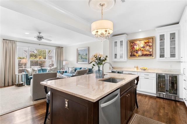 kitchen featuring a sink, dark wood-type flooring, stainless steel dishwasher, beverage cooler, and light stone counters
