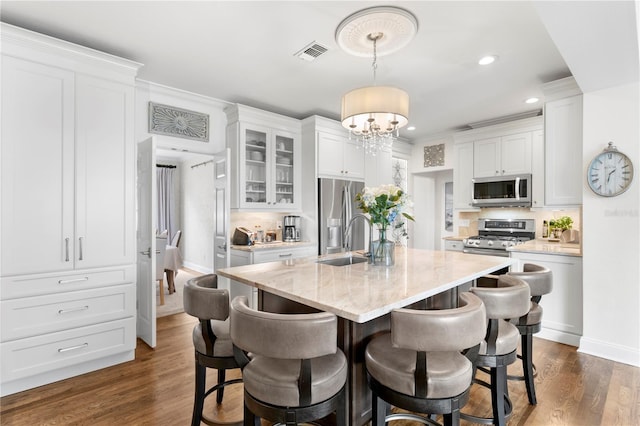 kitchen with a sink, visible vents, appliances with stainless steel finishes, and white cabinetry