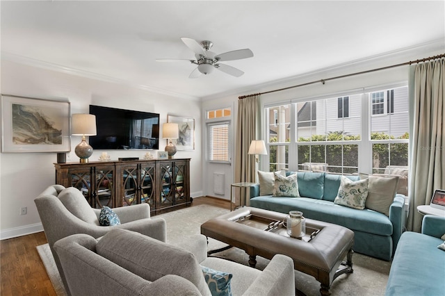 living room featuring wood finished floors, ceiling fan, baseboards, and ornamental molding