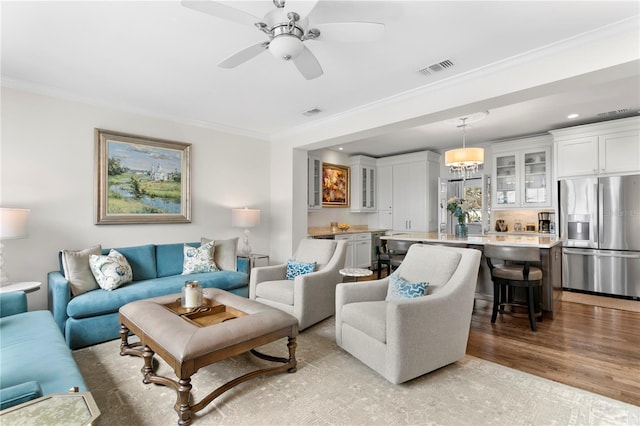 living room featuring ornamental molding, recessed lighting, visible vents, ceiling fan, and wood finished floors