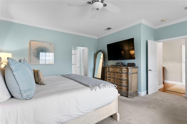 carpeted bedroom featuring visible vents, baseboards, ornamental molding, and ceiling fan