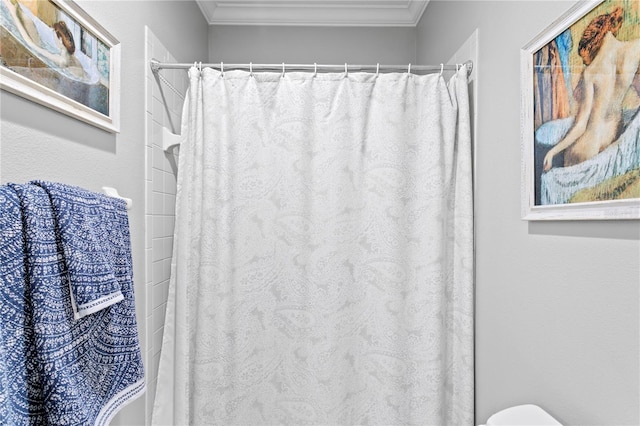 bathroom featuring ornamental molding, toilet, and a shower with shower curtain