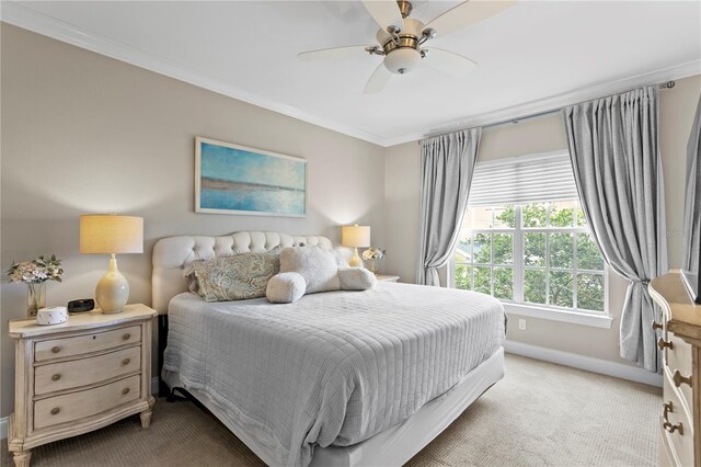 bedroom with carpet, baseboards, ornamental molding, and a ceiling fan