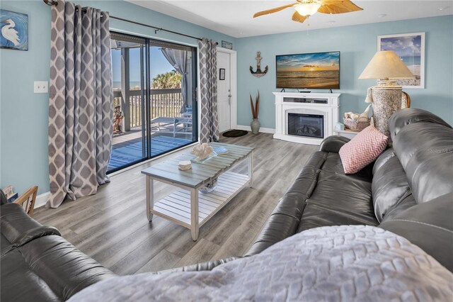 200 120th Ave W Unit 3A, Treasure Island, FL 33706 - living area with baseboards, a ceiling fan, wood finished floors, and a glass covered fireplace