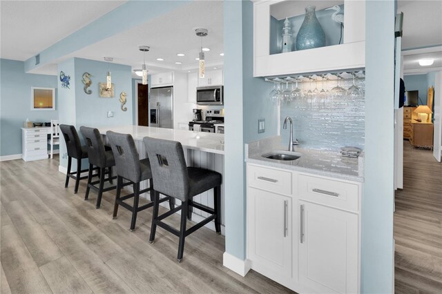 200 120th Ave W Unit 3A, Treasure Island, FL 33706 - kitchen with appliances with stainless steel finishes, a sink, light wood-style floors, white cabinetry, and recessed lighting