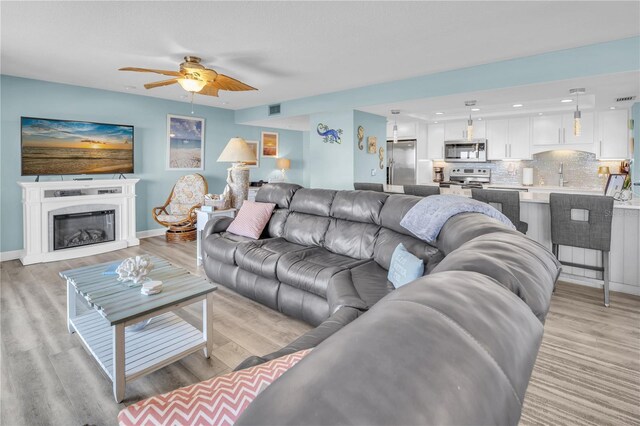 200 120th Ave W Unit 3A, Treasure Island, FL 33706 - living room with a ceiling fan, light wood-style floors, a glass covered fireplace, and recessed lighting