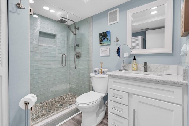 200 120th Ave W Unit 3A, Treasure Island, FL 33706 - full bathroom with vanity, wood finished floors, a stall shower, toilet, and recessed lighting