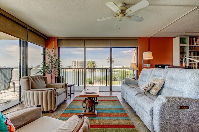 80 Rogers St Unit 2A, Clearwater, FL 33756 - living area with a ceiling fan, a textured ceiling, tile patterned flooring, and a wall of windows