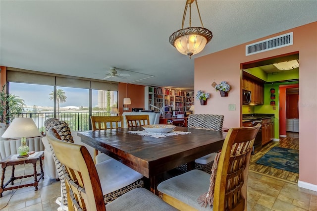 80 Rogers St Unit 2A, Clearwater, FL 33756 - dining space with expansive windows, baseboards, a textured ceiling, visible vents, and a ceiling fan