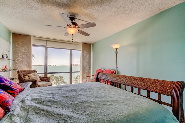80 Rogers St Unit 2A, Clearwater, FL 33756 - bedroom featuring a ceiling fan, floor to ceiling windows, a water view, and a textured ceiling
