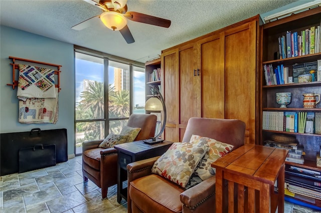 80 Rogers St Unit 2A, Clearwater, FL 33756 - sitting room with a textured ceiling, ceiling fan, and stone finish flooring