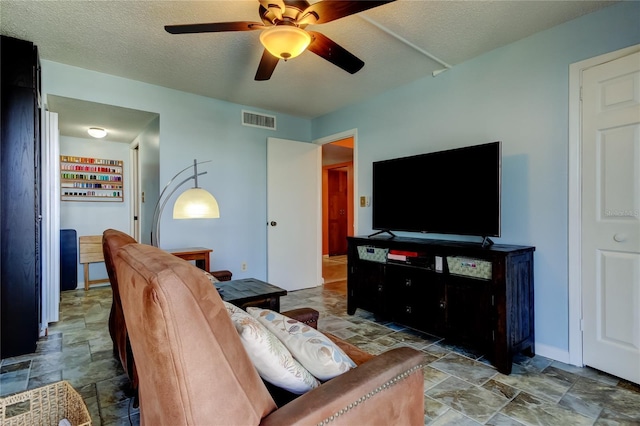 80 Rogers St Unit 2A, Clearwater, FL 33756 - living room featuring stone finish flooring, a ceiling fan, a textured ceiling, baseboards, and visible vents