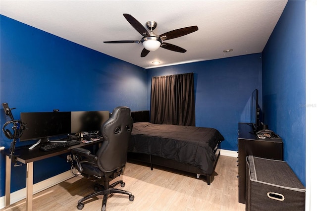 bedroom with baseboards, wood finished floors, and ceiling fan
