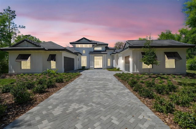 prairie-style house with a garage, a tiled roof, and decorative driveway