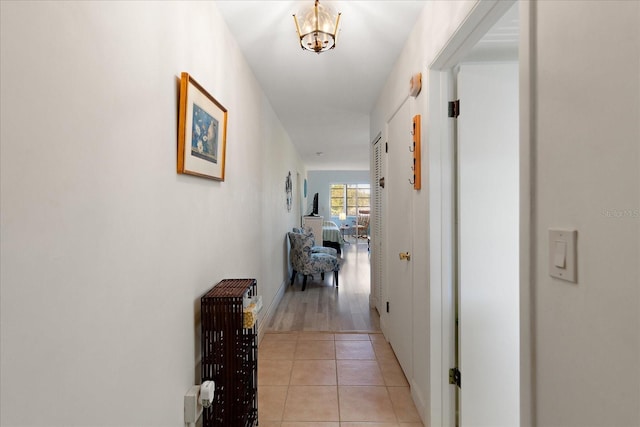 100 Glennes Ln Unit 207, Dunedin, FL 34698 - corridor featuring light tile patterned flooring and a chandelier